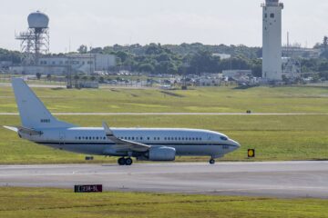 commercial aircraft taxiing with a control tower in the background